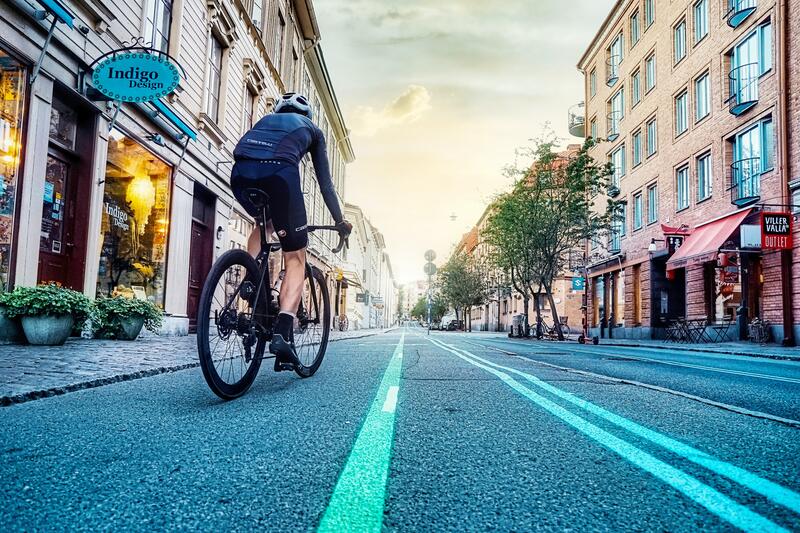 Man på cykel som cyklar genom ett soligt Göteborg. 