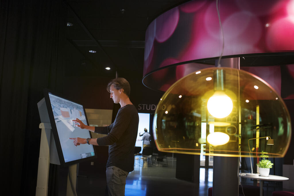 Person jobbar med en stor interaktiv skärm i Visual Arenas studio 