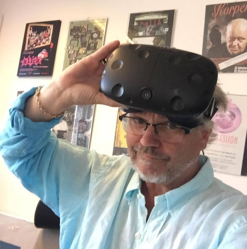 Jonas Myrstrand står med VR glasögon på pannan medans han ler in i kameran. 