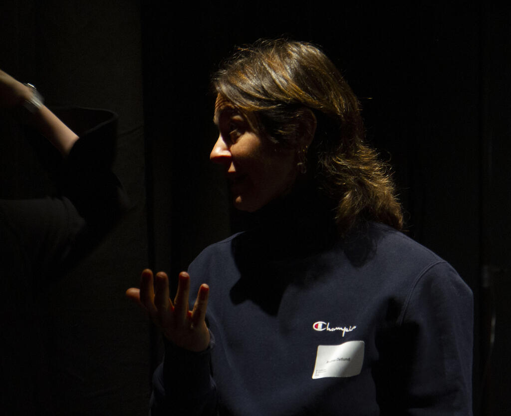 Kvinna står och samtalar i en mörk studio